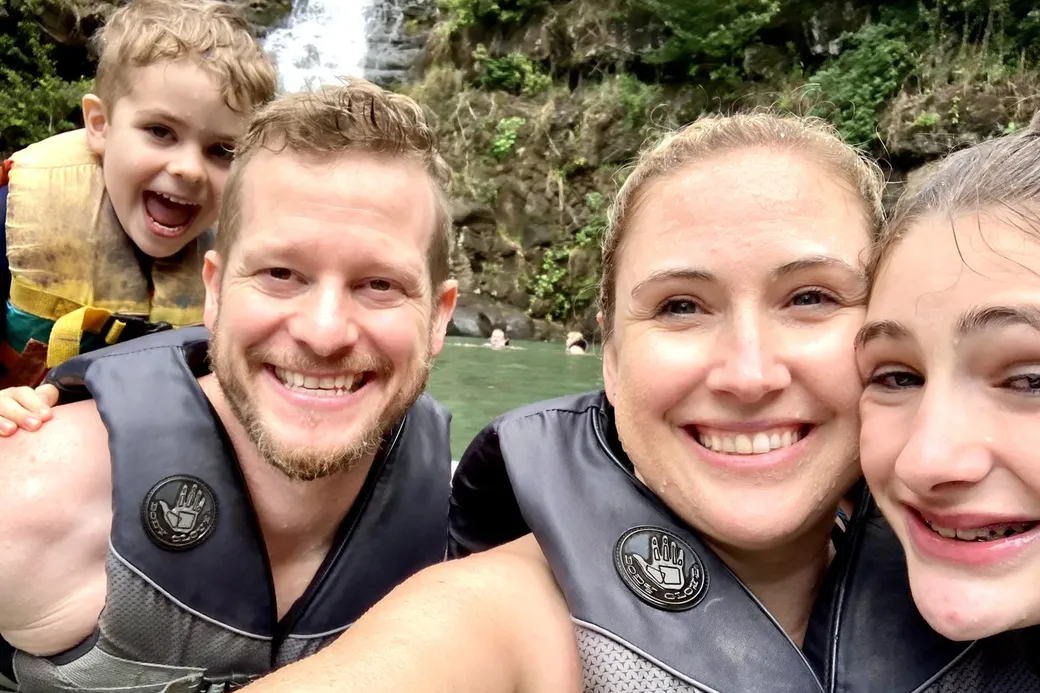 Josh Cypher with his family swimming at a waterfall